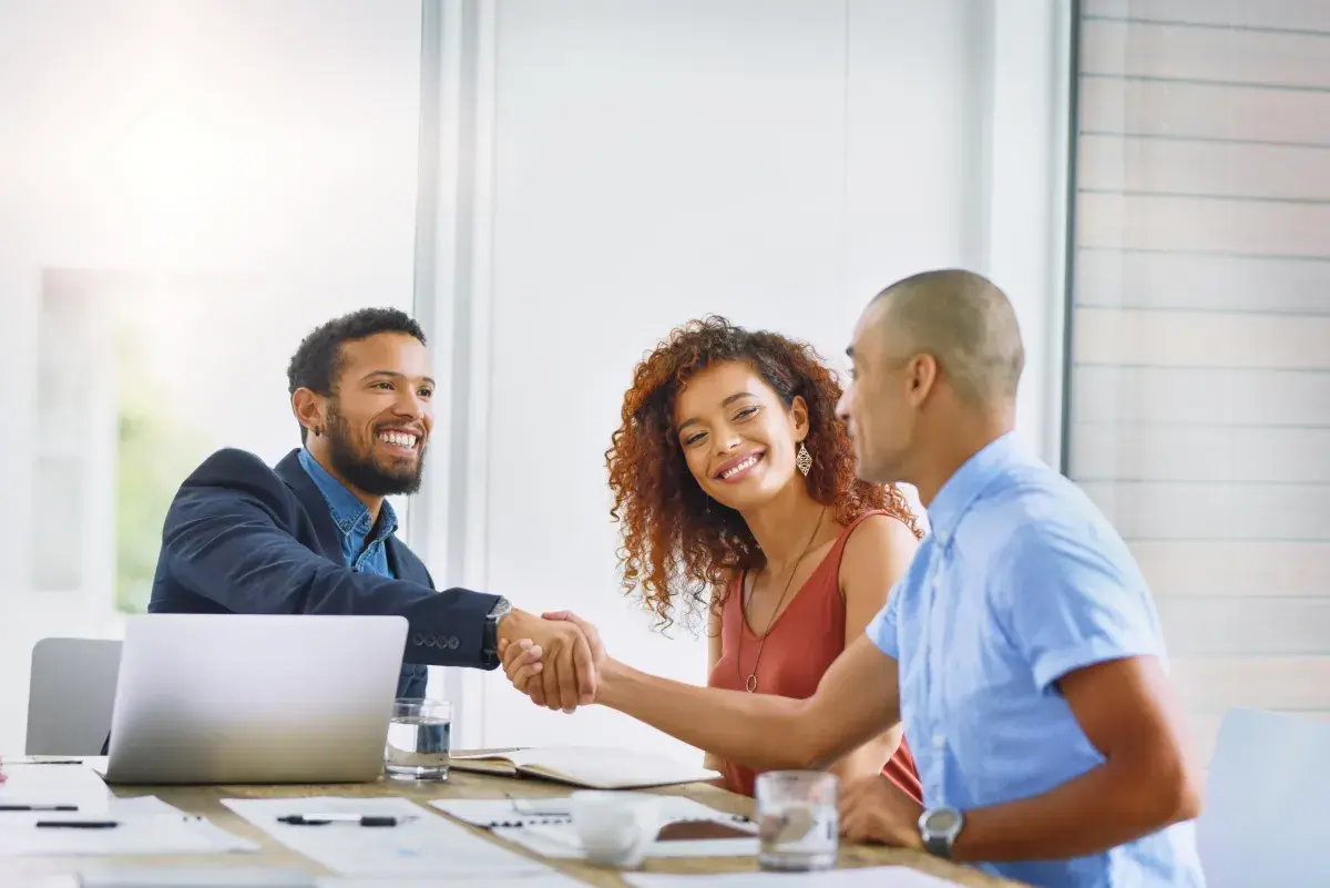 Two men and woman in meeting with laptop