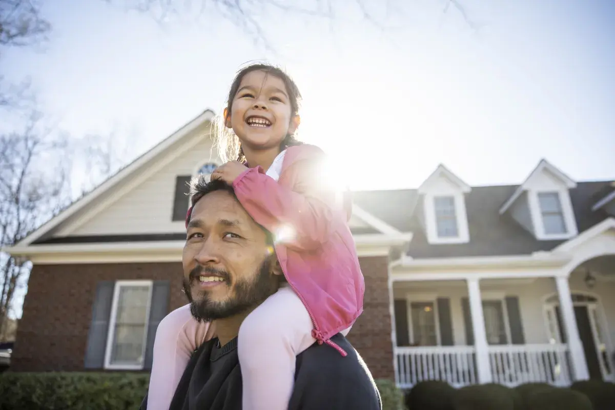 Father and daughter with house