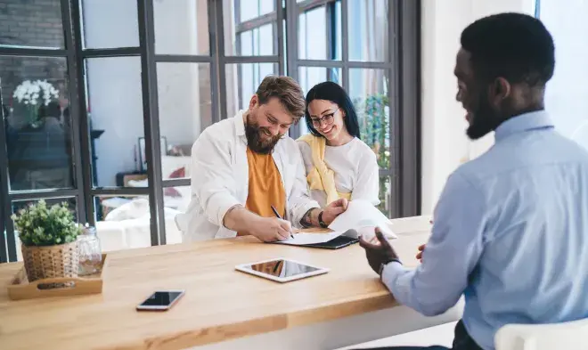 happy couple signing paperwork for new purchase