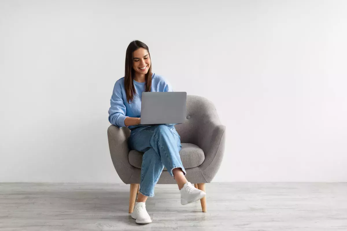 High school student sitting in chair with laptop