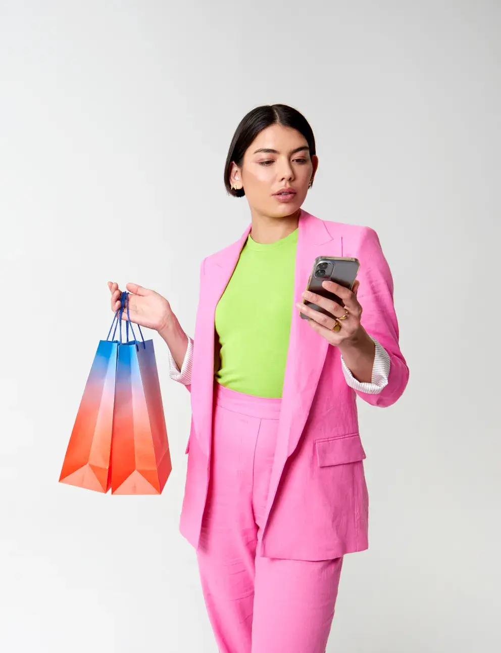Woman with shopping bags looking at phone Woman with shopping bags looking at phone